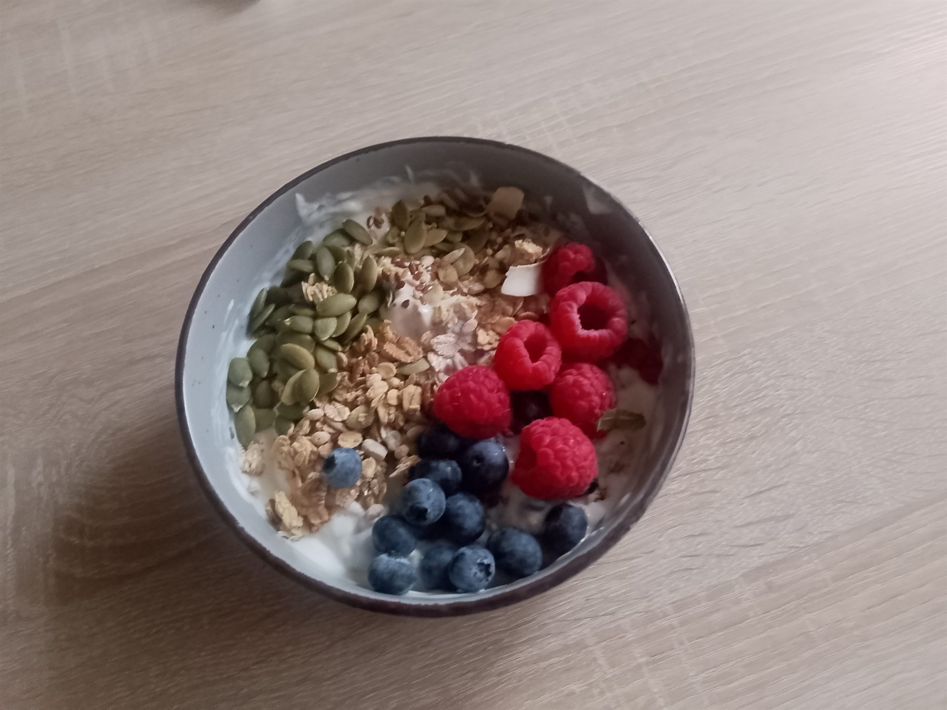 Vegan bessenbowl met sojakwark, pompoenpitten, muesli, frambozen en blauwe bessen